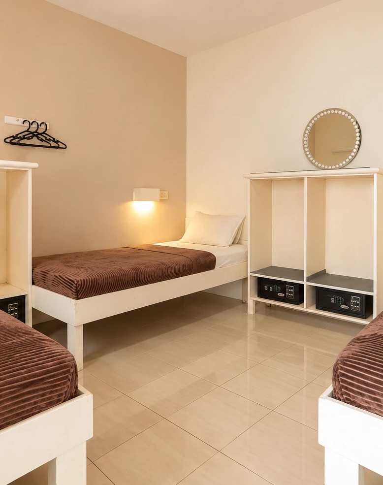 Dorm room with single beds, reading lights and personal safes